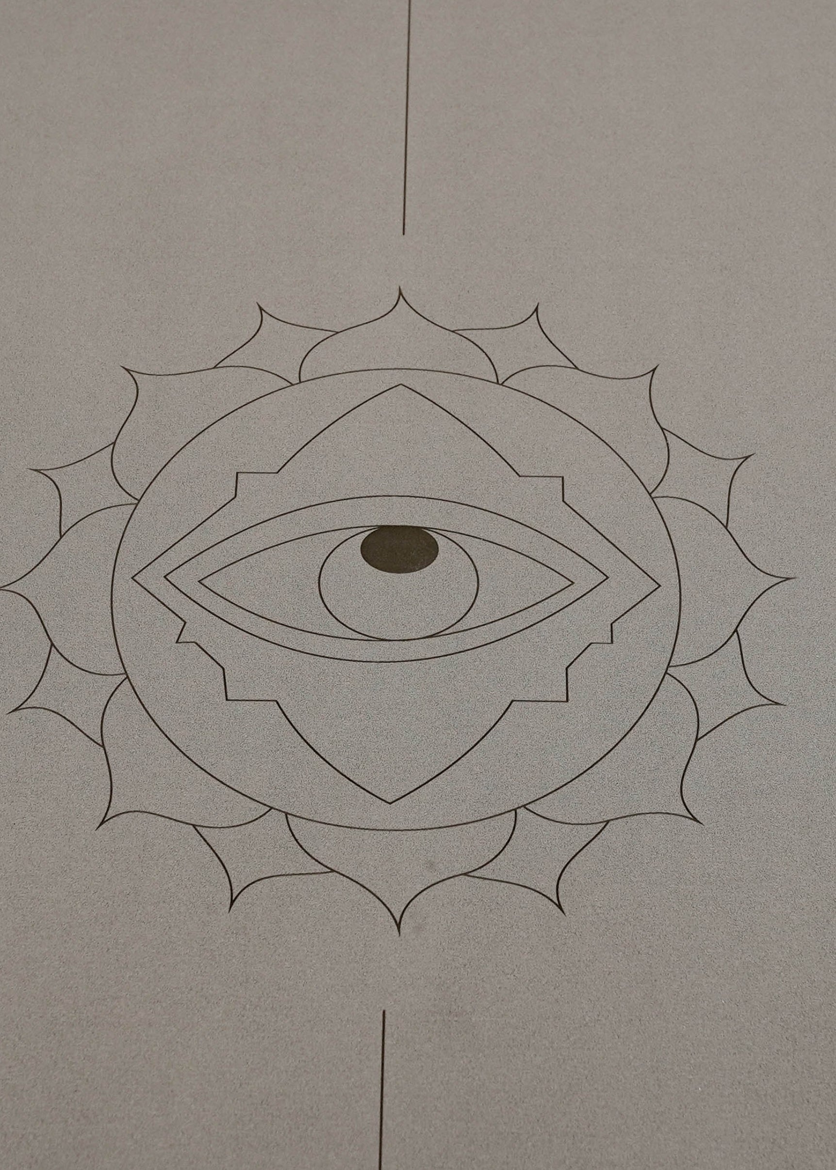 A minimalist yoga mat in a warm taupe-gray color called Eclipse Shadow, featuring a black line-art design of a lotus flower enclosing an eye, with vertical centerlines extending to the top and bottom edges, called Throat Eye shown on a white background.